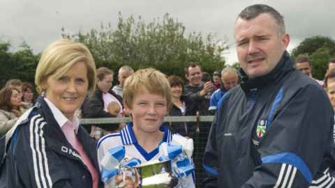 Monaghan County Chair Paul Curran and sponsor of the under 12 juvenile final's Deirdre McElroy from Gerry's fresh fruit and veg presenting, Latton's under 12 captrian Conor McCabe with the U12 Division 4 Cup in Blackhill. Picture by Philip Fitzpatrick